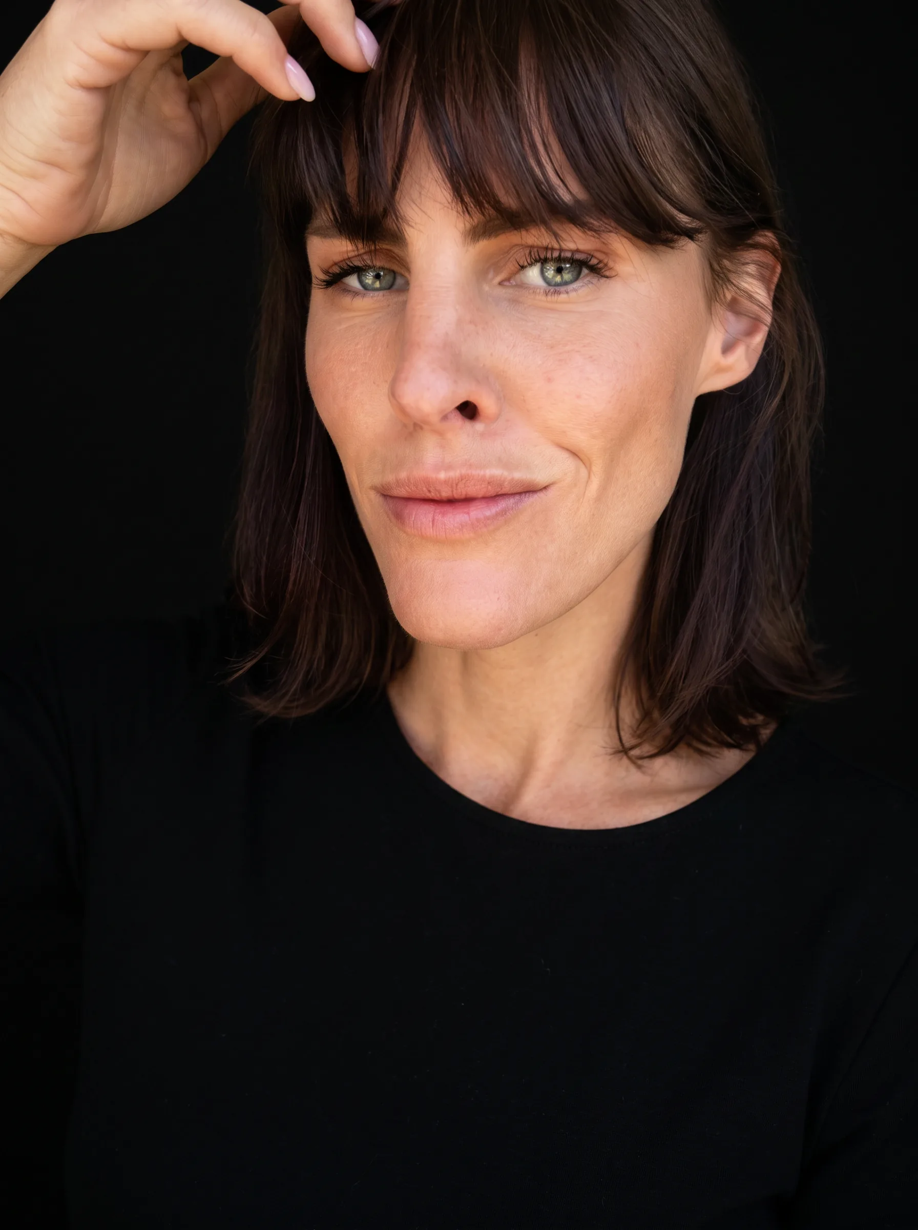 Portrait au flash d'une femme au sourire franc, regardant l'objectif